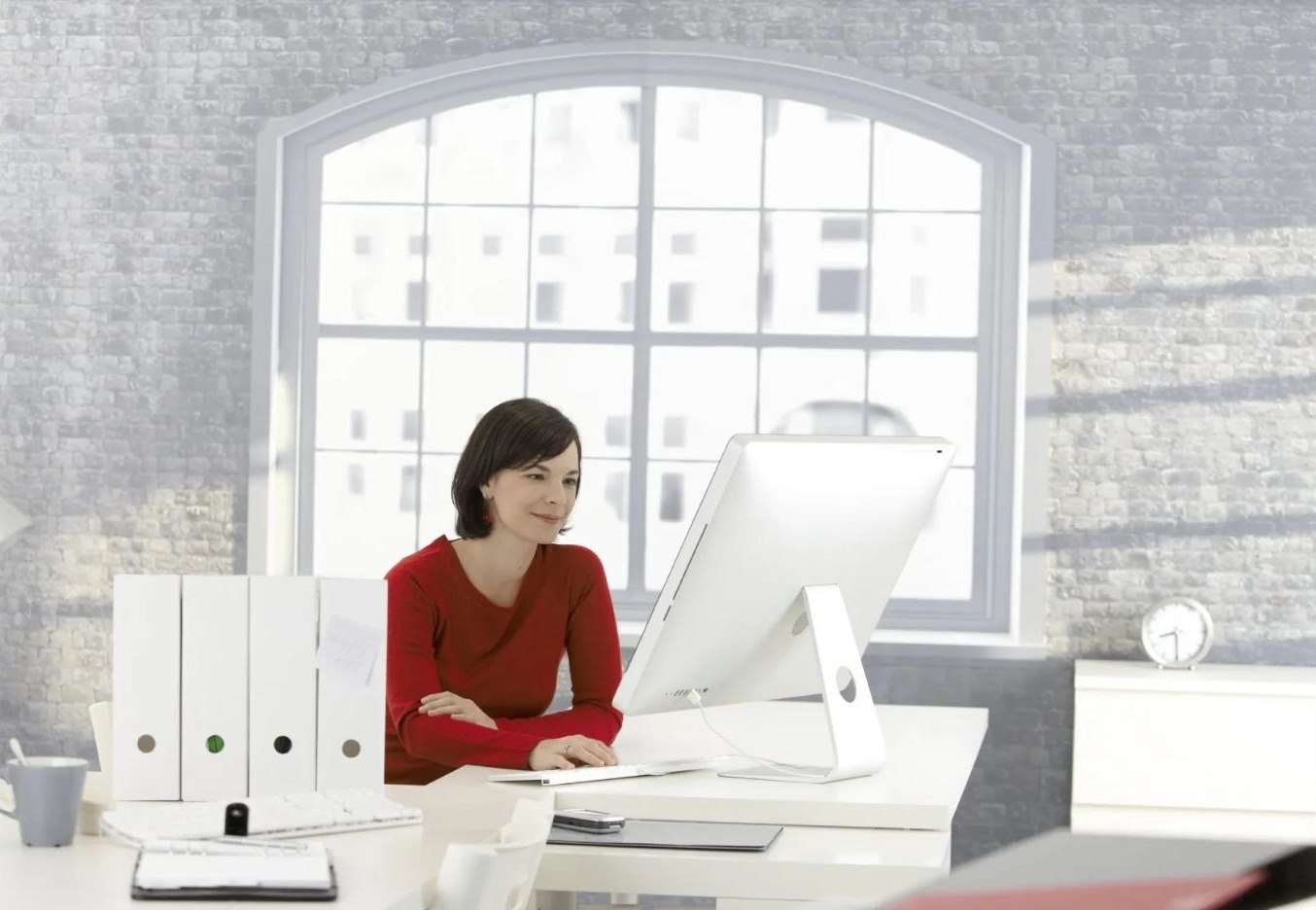 Frau arbeitet im Sitzen an einem Computer