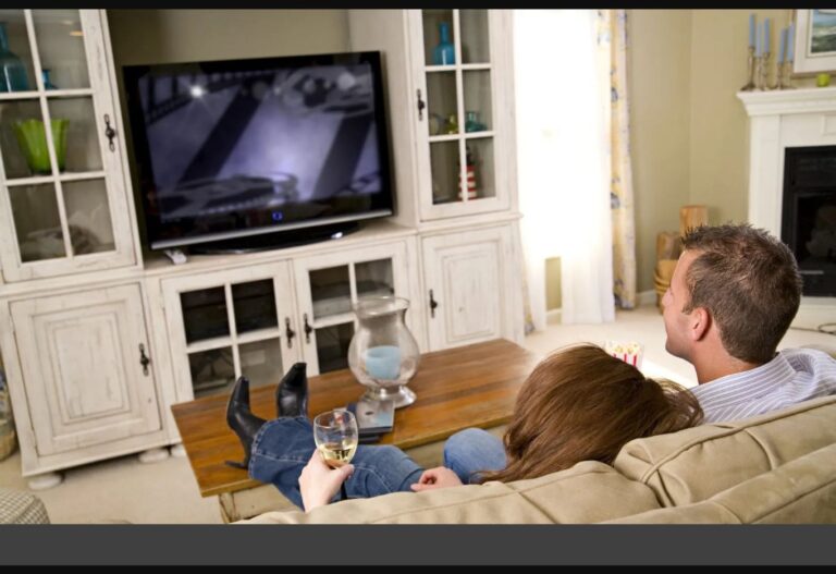 Pärchen sitzt vor dem Fernseher und schaut