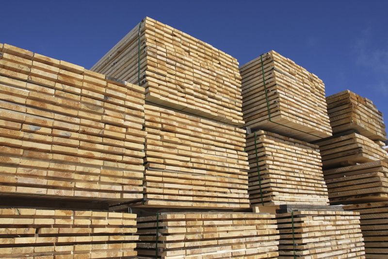 Gestapelte Holzpaletten unter blauem Himmel