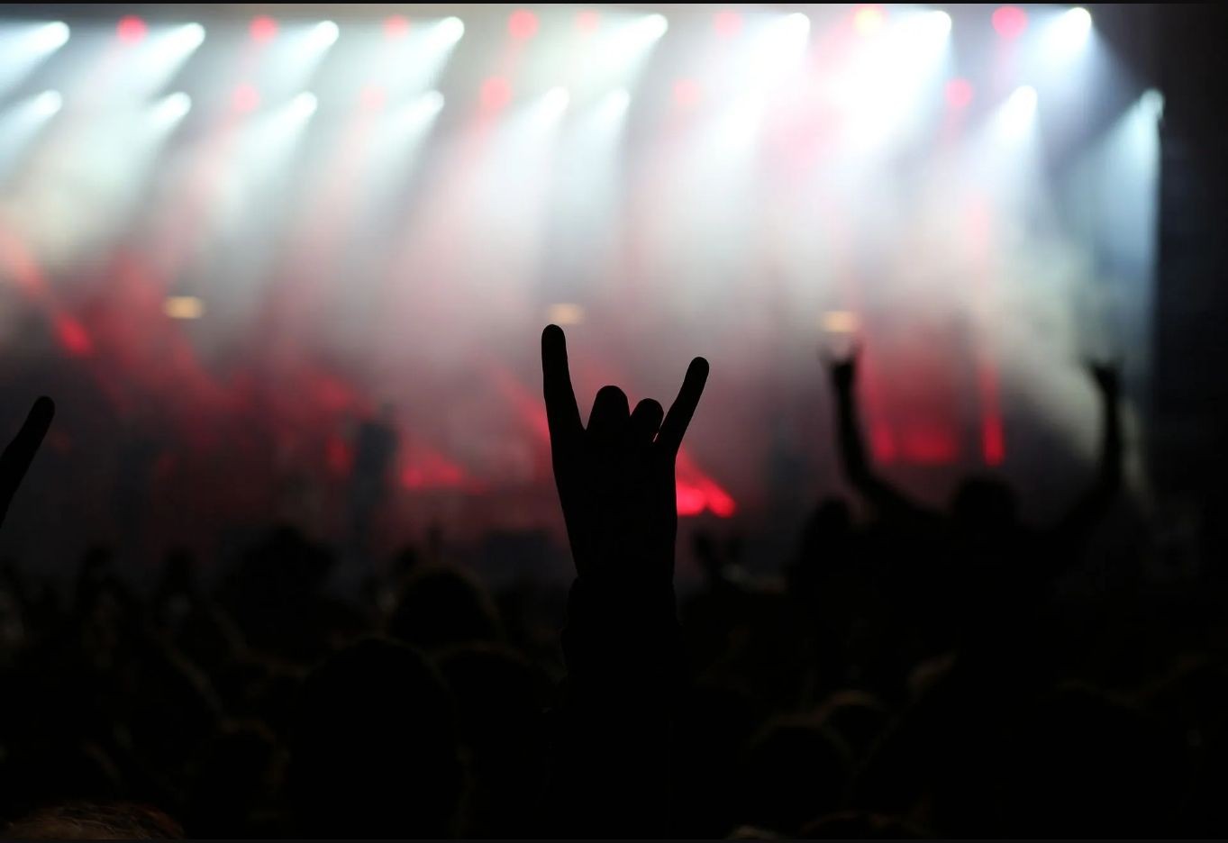 Publikum bei einem Rockkonzert vor hell erleuchteter Bühne