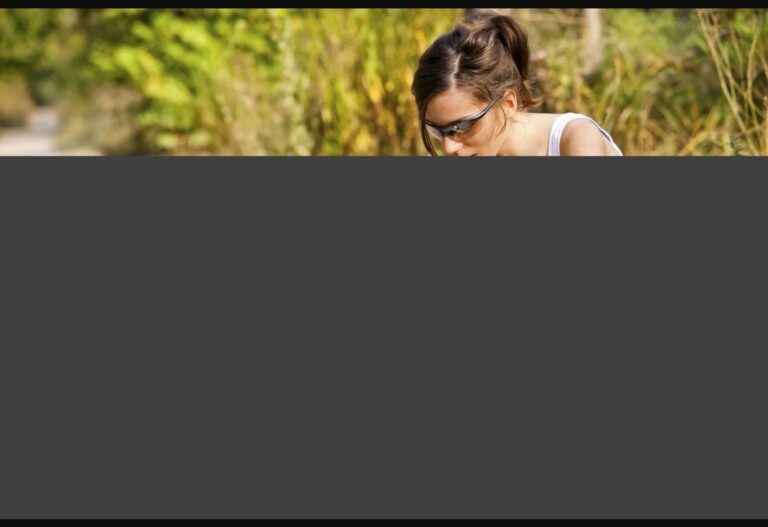 Frau mit Sonnenbrille sitzt im Freien