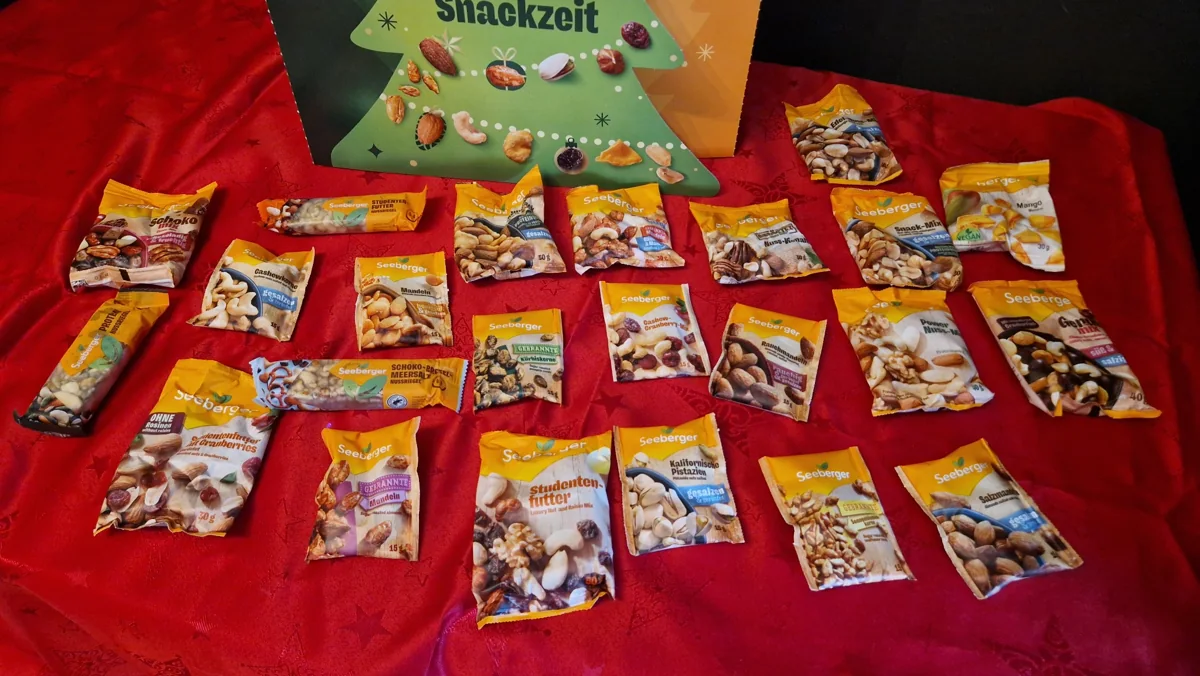 Nüsse, Trockenfrüchte und Nussriegel aus dem Seeberger Adventskalender 2026 auf roter Tischdecke